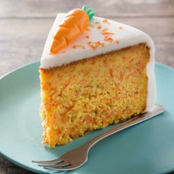 Delicious Slice of Carrot Cake decorated with carrot toppings and frosting.
